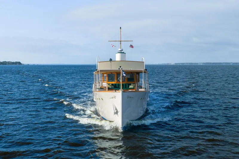 Slide: The Image of 1939 Mathis Trumpy Fantail Houseboat cruising on open water under clear skies. - 41