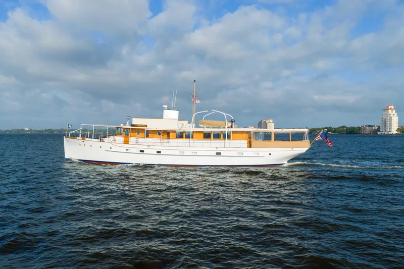 Slide: The Image of 1939 Mathis Trumpy Fantail Houseboat cruising on a sunny day with cityscape background. - 45
