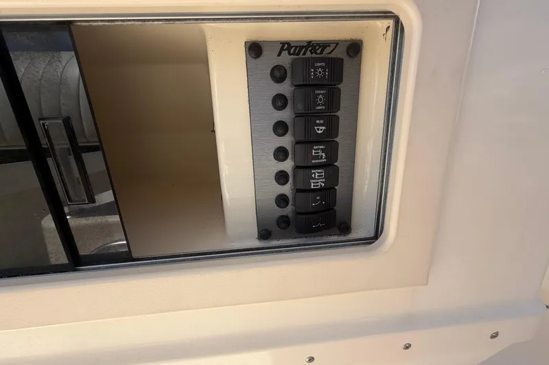 Slide: The Image of Control panel of a 2006 Parker 23SE Center Console boat with labeled switches. - 13