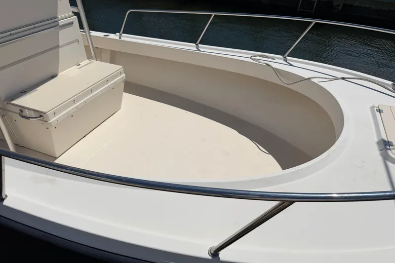 Slide: The Image of 2006 Parker 23SE Center Console boat deck with seating and railing, docked by water. - 26