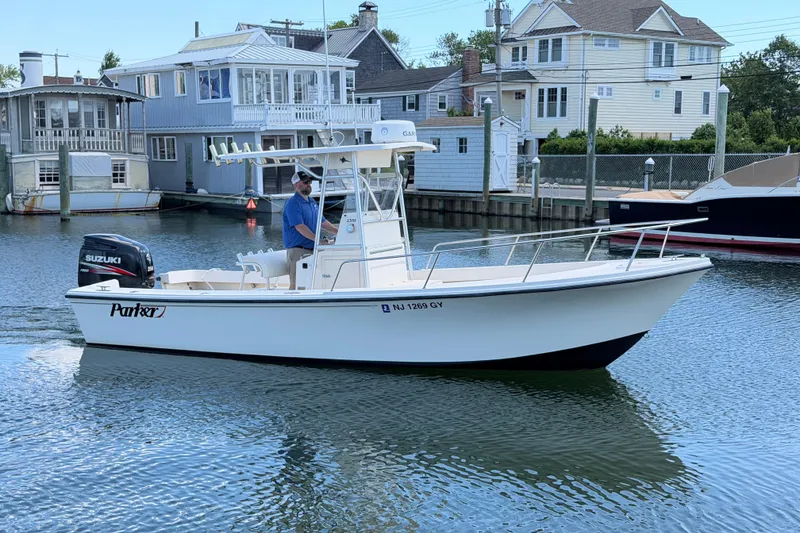 Slide: The Image of 2006 Parker 23SE Center Console boat cruising near waterfront homes. - 4