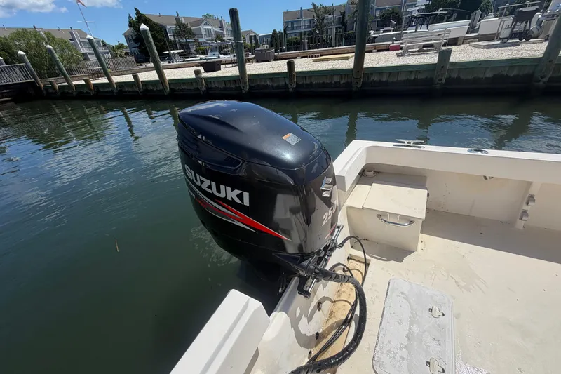 Slide: The Image of 2006 Parker 23SE Center Console with Suzuki outboard motor docked by waterfront homes. - 6