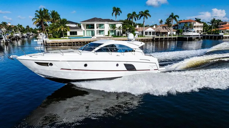 Slide: The Image of 2016 Beneteau GRAN TURISMO 49 yacht cruising in a scenic waterfront setting. - 2
