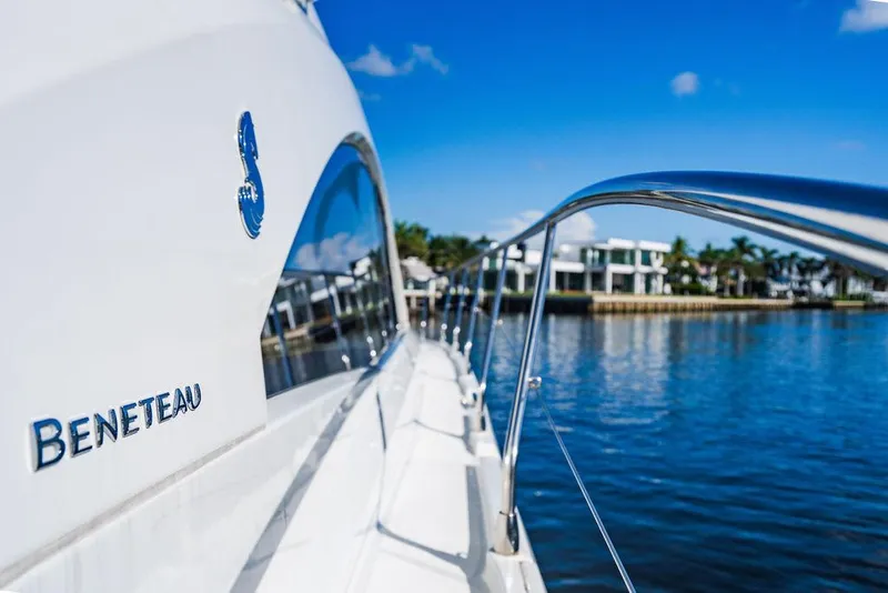 Slide: The Image of 2016 Beneteau Gran Turismo 49 yacht on serene water with modern homes in background. - 35