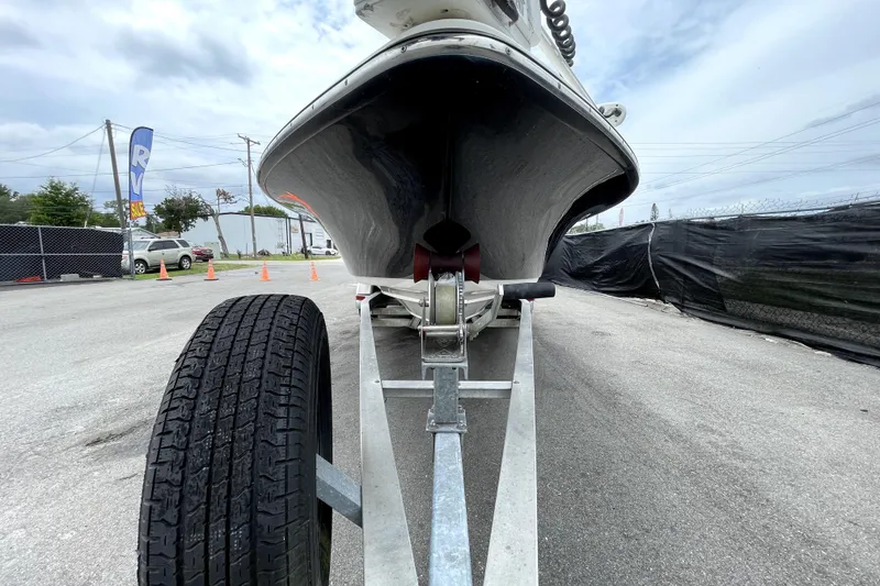 Slide: The Image of 2019 ShearWater 25 LTZ boat on trailer, parked outdoors under cloudy sky. - 11