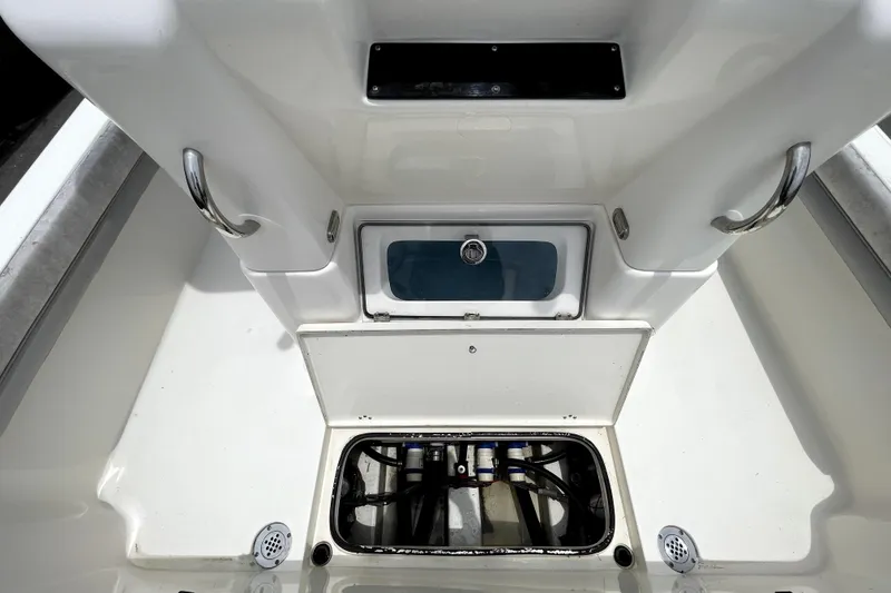 Slide: The Image of 2019 ShearWater 25 LTZ boat interior with storage compartments and stainless steel handles. - 16