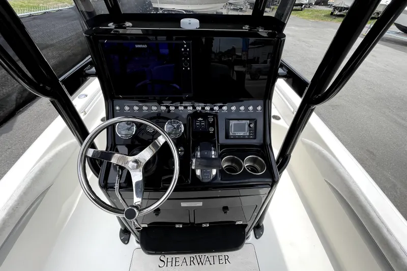 Slide: The Image of 2019 ShearWater 25 LTZ boat dashboard with steering wheel and control panel. - 18
