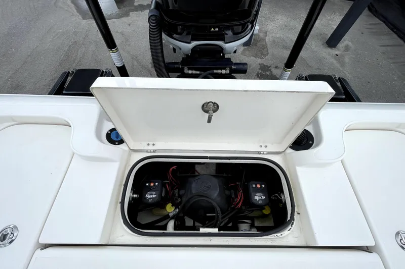 Slide: The Image of 2019 ShearWater 25 LTZ boat battery compartment with open hatch, showcasing electrical components. - 47