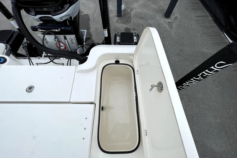 Slide: The Image of 2019 ShearWater 25 LTZ boat with open storage compartment and visible engine components. - 51