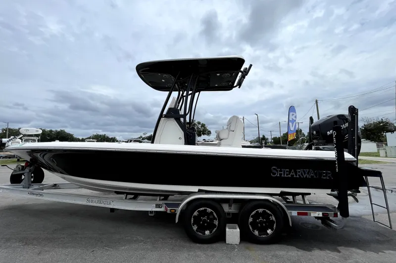 Slide: The Image of 2019 ShearWater 25 LTZ boat on trailer under cloudy sky. - 8