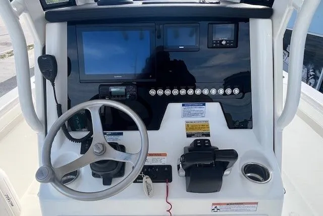 Slide: The Image of Center console of 2025 World Cat 235 TE boat with steering wheel and navigation controls. - 4