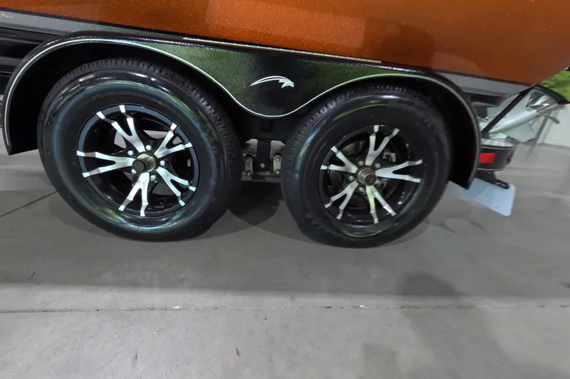 Slide: The Image of Trailer wheels of a 2021 Falcon Boats 195, featuring sleek black and silver rims. - 18