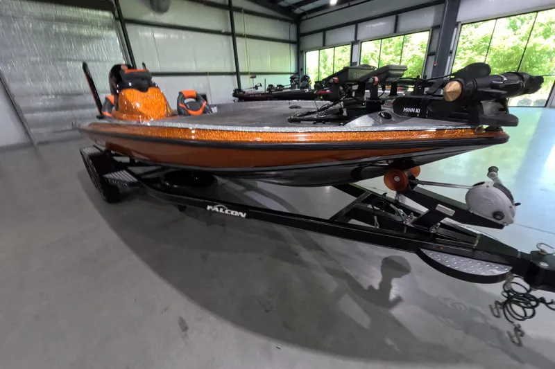 Slide: The Image of 2021 Falcon Boats 195 in showroom, orange and black, equipped with Minn Kota trolling motor. - 6