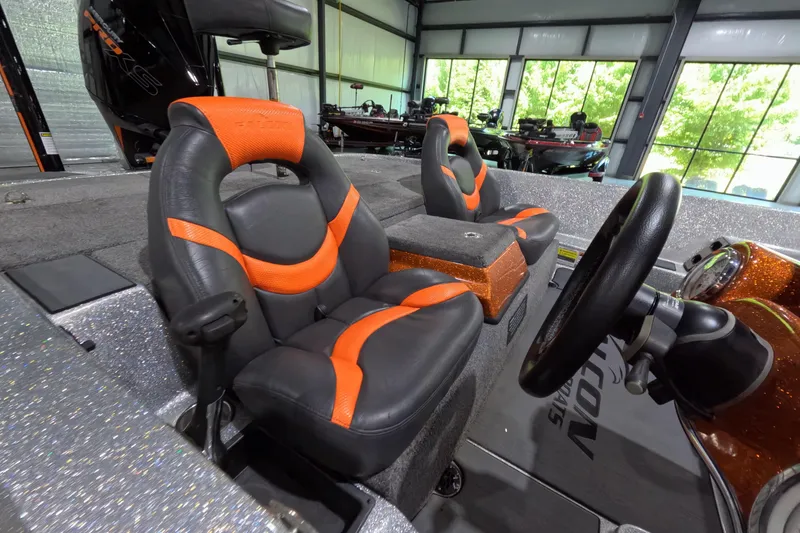 Slide: The Image of 2021 Falcon Boats 195 interior with orange and black seats in a showroom. - 9