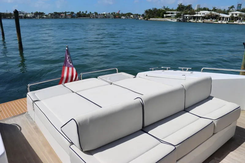 Slide: The Image of Luxury yacht deck with white seating, American flag, and scenic waterfront view. CNM 50, 2010 model. - 10