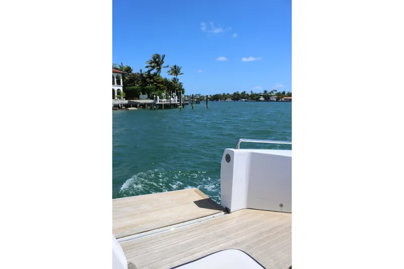 Slide: The Image of Boat deck view of tropical waterfront homes, clear blue sky, and calm waters. - 26