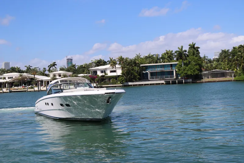 Slide: The Image of Luxurious CNM 50 yacht cruising near waterfront homes, clear blue sky, 2010 model. - 3