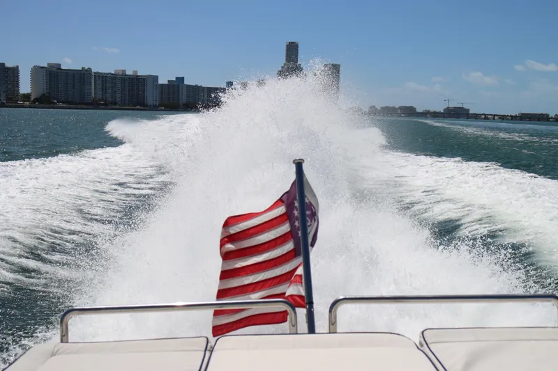 Slide: The Image of Speedboat cruising with American flag, creating waves near city skyline, CNM 50 model, 2010. - 8