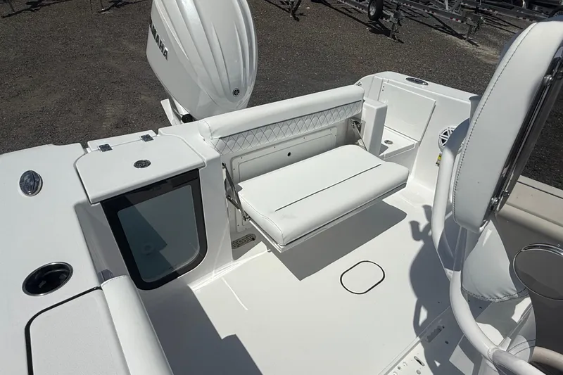 Slide: The Image of 2026 Sportsman Open 232 Center Console boat interior with white seating and storage compartments. - 11