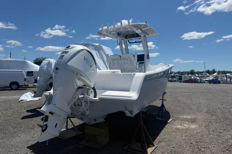 Slide: The Image of 2026 Sportsman Open 232 Center Console boat with dual engines on display outdoors. - 2