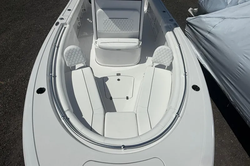 Slide: The Image of 2026 Sportsman Open 232 Center Console boat interior with white cushioned seating. - 4
