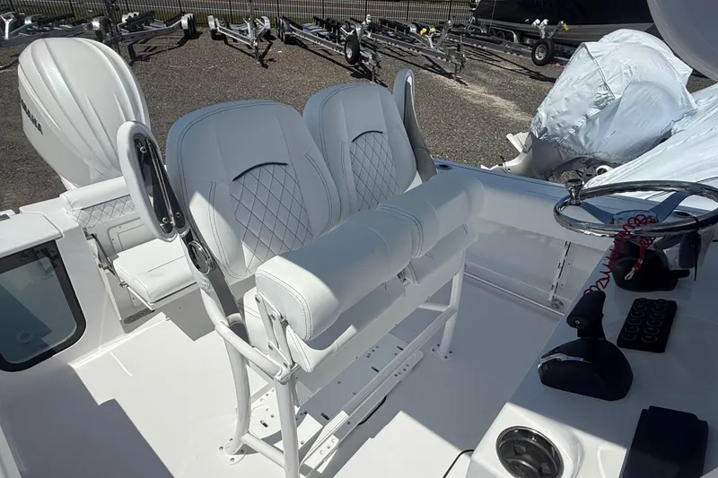 Slide: The Image of 2026 Sportsman Open 232 Center Console boat interior with white seating and steering wheel. - 6
