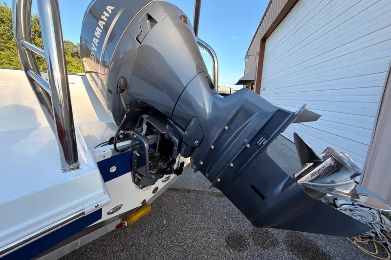 Slide: The Image of 2022 Hurricane SunDeck Sport 205 OB with Yamaha outboard motor, parked near a garage. - 3