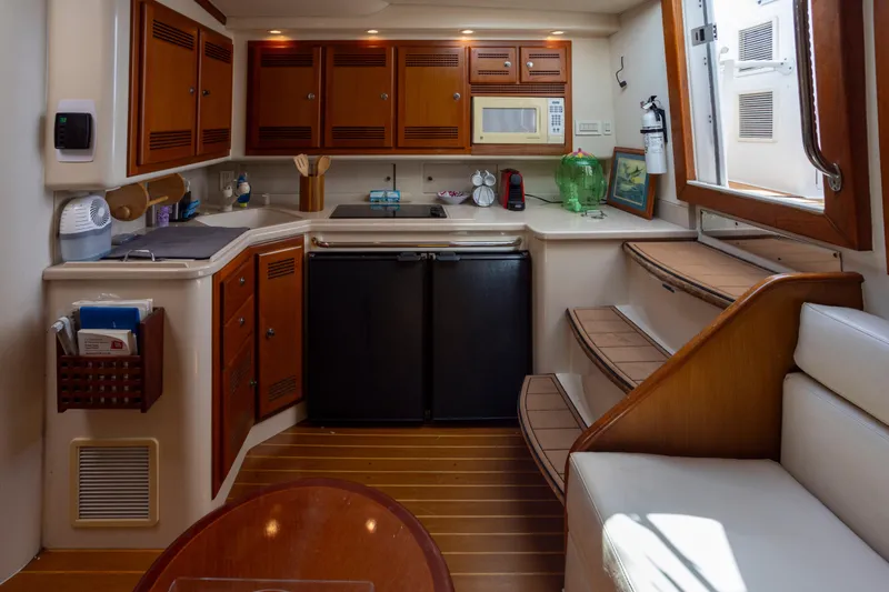 Slide: The Image of Interior of 2000 Cabo 45 Express yacht kitchen with wooden cabinets and modern appliances. - 3