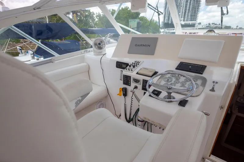 Slide: The Image of Helm of 2000 Cabo 45 Express yacht with Garmin navigation system and white seating. - 5