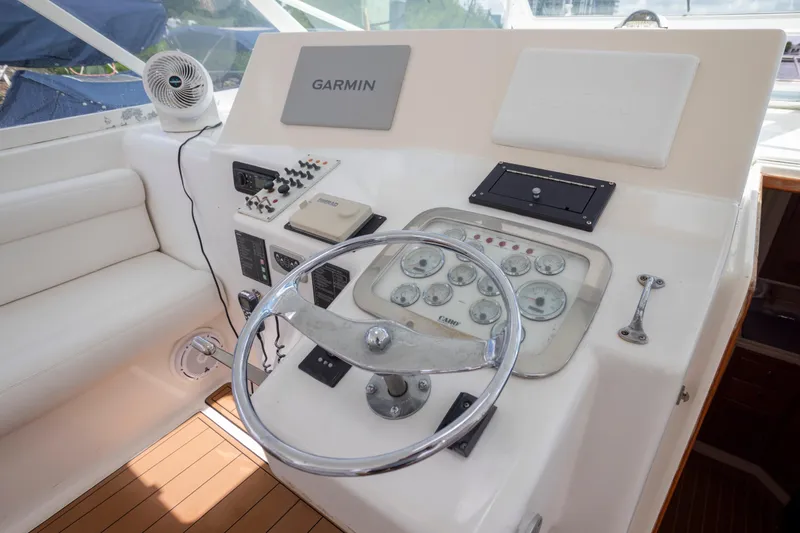 Slide: The Image of Helm of 2000 Cabo 45 Express yacht with Garmin navigation system and classic gauges. - 6