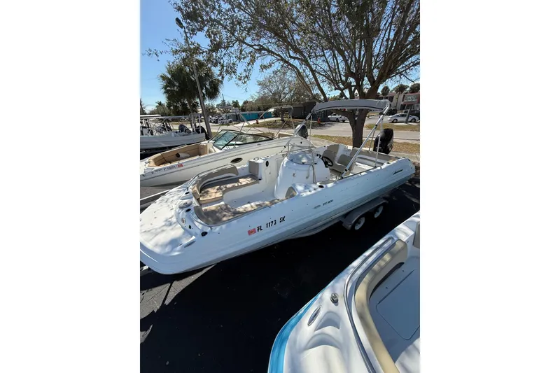 Slide: The Image of 2017 Hurricane SunDeck Sport CC 231 OB boat with canopy, parked outdoors under a tree. - 4