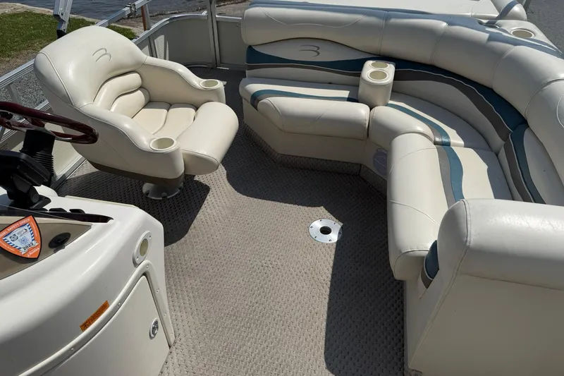 Slide: The Image of 2005 Bennington 2075RL boat interior with plush seating and steering console. - 10