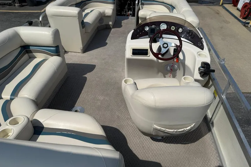 Slide: The Image of 2005 Bennington 2075RL pontoon boat interior with beige seating and steering console. - 16