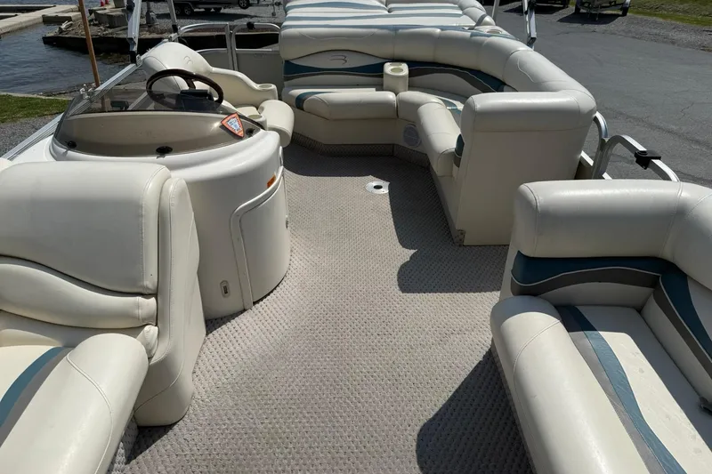 Slide: The Image of 2005 Bennington 2075RL pontoon boat interior with white seating and steering console. - 7
