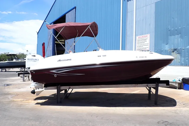 The Image of 2021 Hurricane SunDeck Sport 185 OB boat on display outside a blue building. - 0
