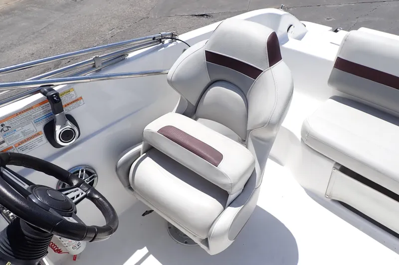 Slide: The Image of 2021 Hurricane SunDeck Sport 185 OB boat interior with steering wheel and cushioned seating. - 12
