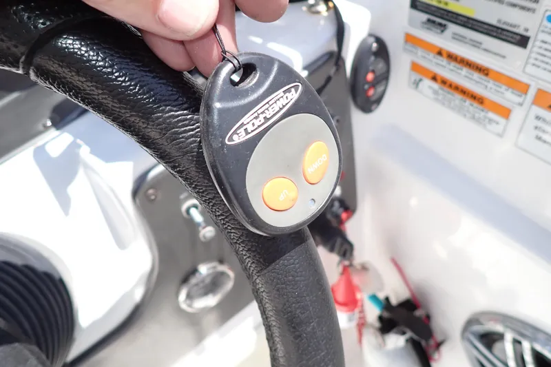 Slide: The Image of Close-up of a remote control on a 2021 Hurricane SunDeck Sport 185 OB boat steering wheel. - 16