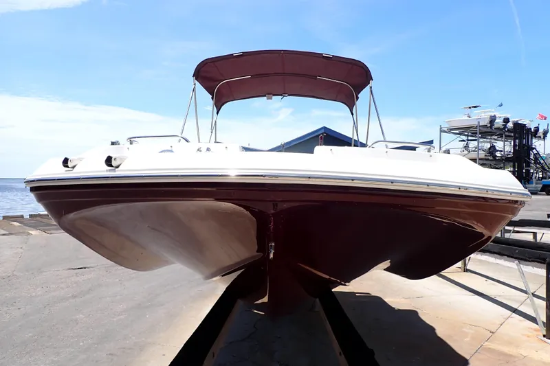 Slide: The Image of 2021 Hurricane SunDeck Sport 185 OB boat with canopy, docked on a sunny day. - 2