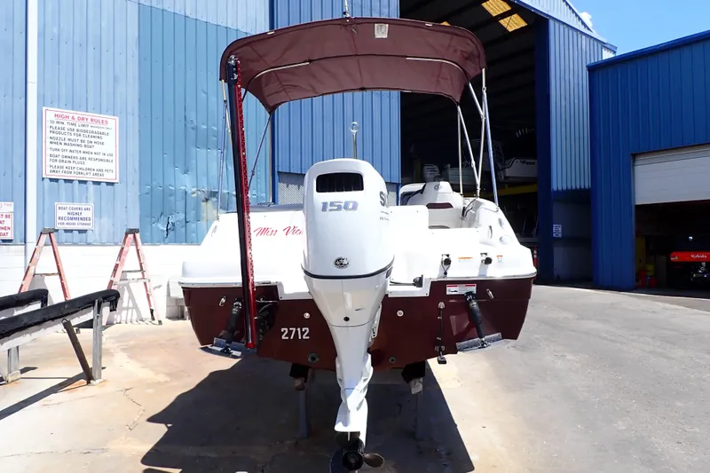 Slide: The Image of 2021 Hurricane SunDeck Sport 185 OB boat with outboard motor in a marina setting. - 3