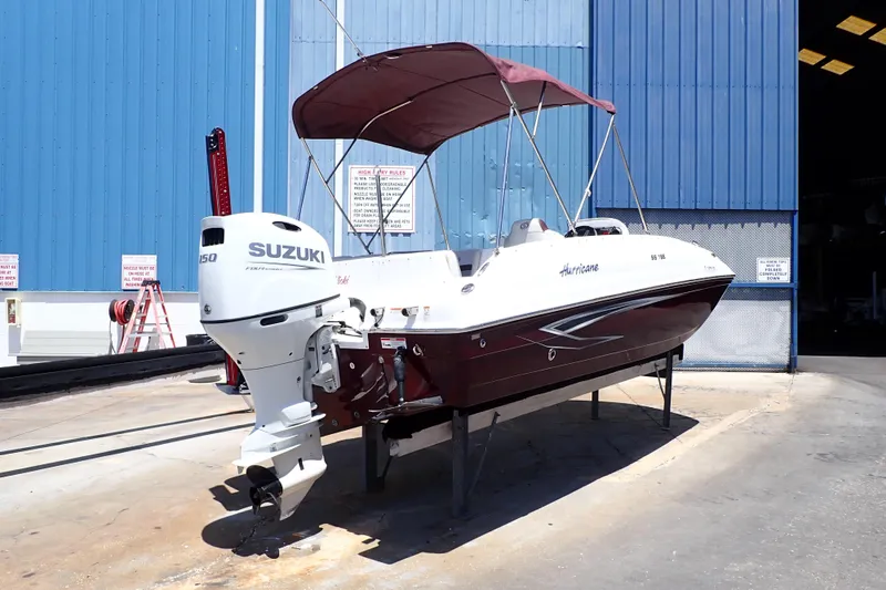 Slide: The Image of 2021 Hurricane SunDeck Sport 185 OB boat with Suzuki outboard motor in a marina setting. - 4