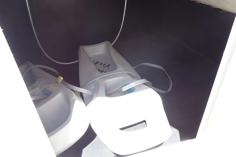 Slide: The Image of Storage compartment of 2021 Hurricane SunDeck Sport 185 OB with two white containers. - 40