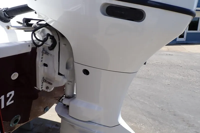 Slide: The Image of 2021 Hurricane SunDeck Sport 185 OB outboard motor close-up in a marina setting. - 56