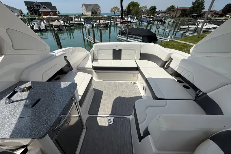 Slide: The Image of 2016 Chaparral 307 SSX boat interior with seating and kitchenette, docked at marina. - 13