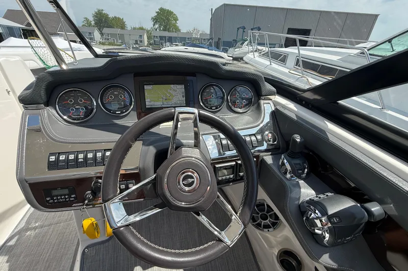 Slide: The Image of 2016 Chaparral 307 SSX boat dashboard with steering wheel and navigation controls. - 16