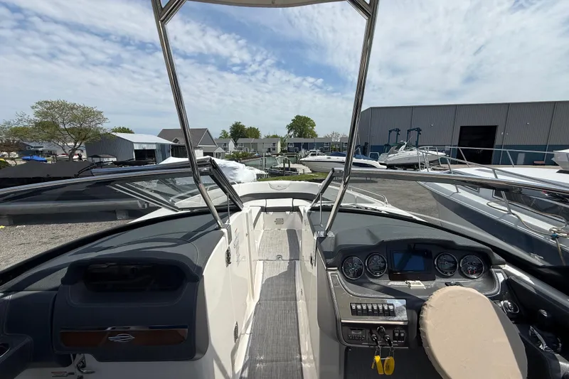 Slide: The Image of 2016 Chaparral 307 SSX boat interior with dashboard and steering wheel, docked outdoors. - 17
