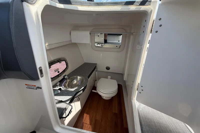 Slide: The Image of Interior of 2016 Chaparral 307 SSX boat bathroom with sink and toilet. - 18