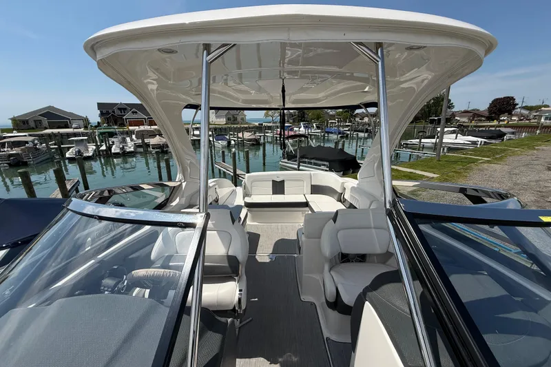 Slide: The Image of 2016 Chaparral 307 SSX boat interior at marina, showcasing seating and helm. - 19