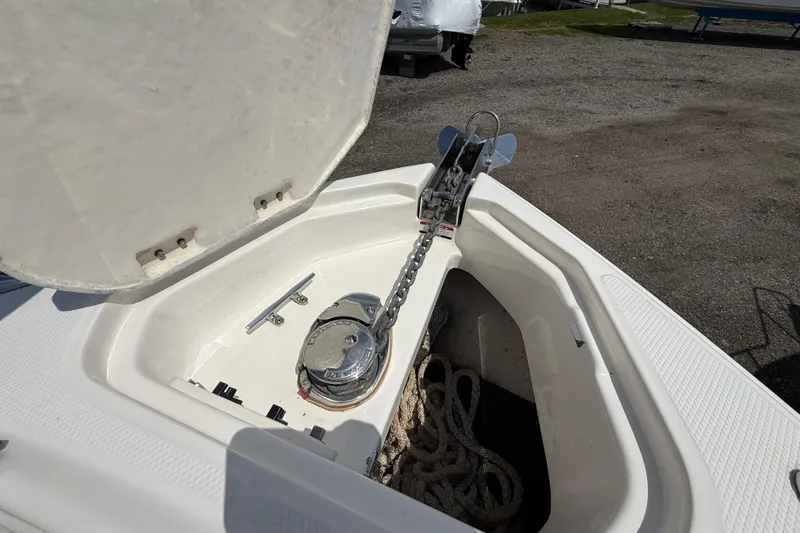 Slide: The Image of Open anchor compartment on 2016 Chaparral 307 SSX boat, showing chain and rope storage. - 25