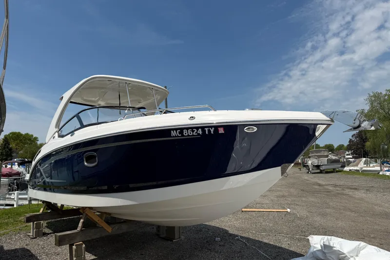 Slide: The Image of 2016 Chaparral 307 SSX boat on display, blue and white exterior, parked outdoors. - 3