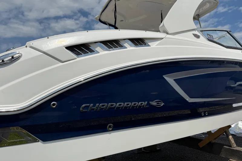 Slide: The Image of 2016 Chaparral 307 SSX boat, sleek design, white and blue exterior, side view. - 4
